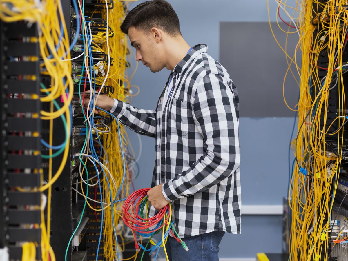 Network engineer working on cabling in a server rack