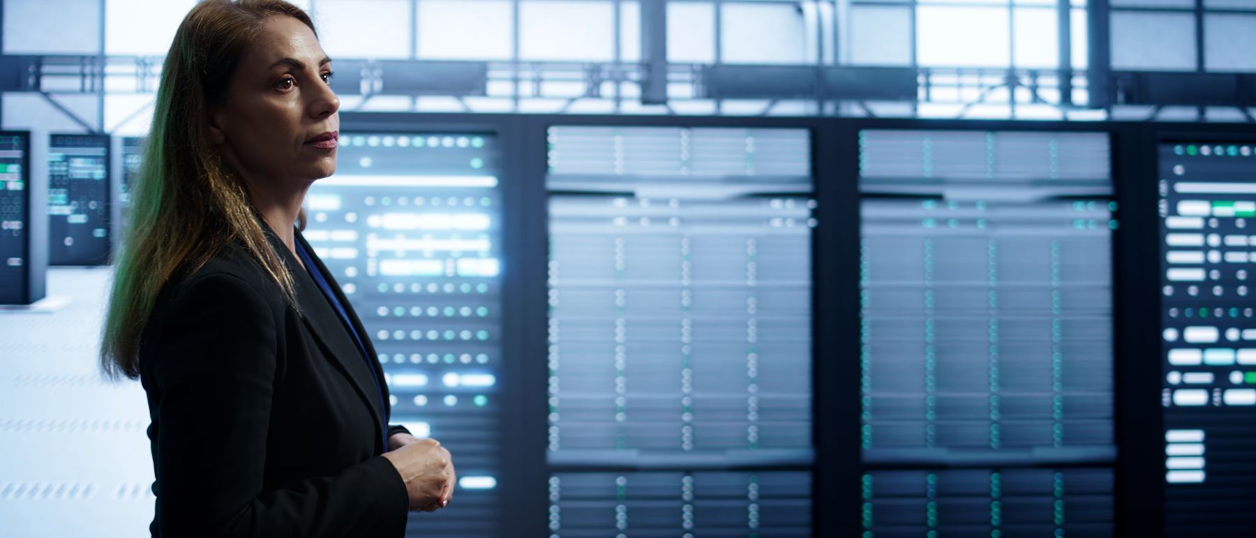Engineer in front of monitoring screens in a data centre